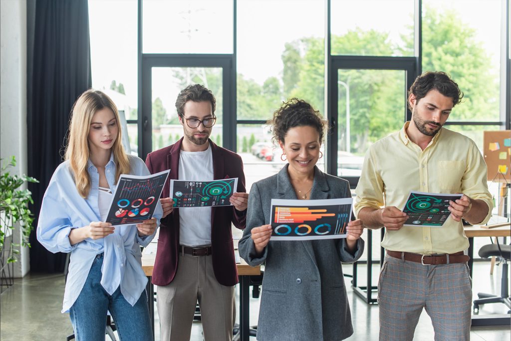 Multiethnic business people looking at documents with charts in office