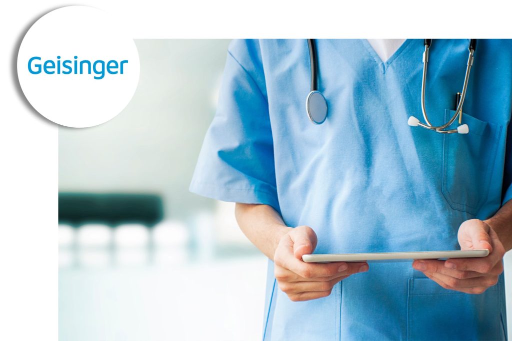 Healthcare professional in blue scrubs holding a tablet, with a stethoscope around their neck and the Geisinger logo in the corner.