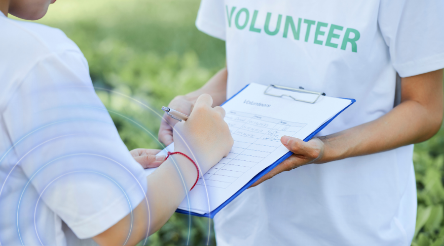 person filling out a form and a volunteer