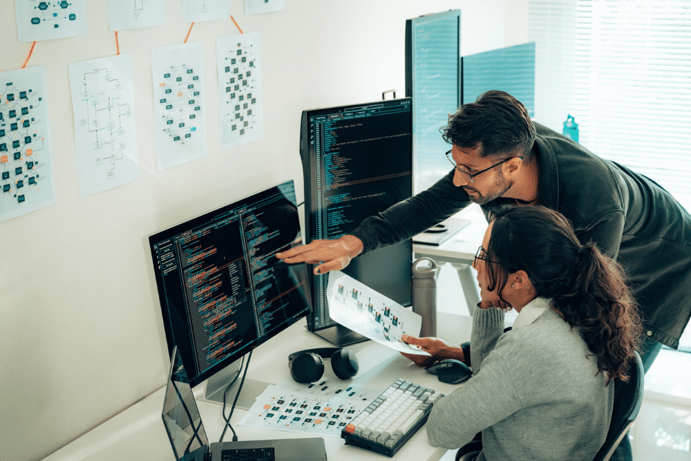 Two software developers collaborating at a workstation.